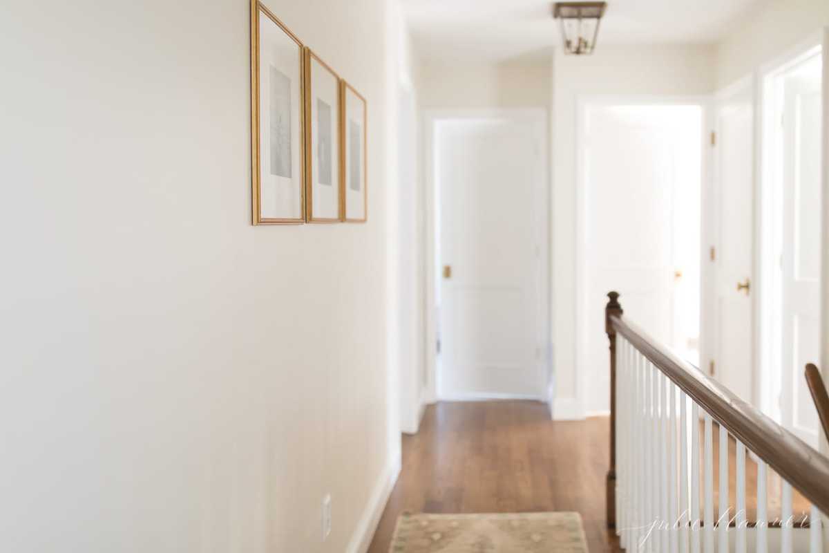 A white painted upstairs hallway with lots of doors in a vintage home