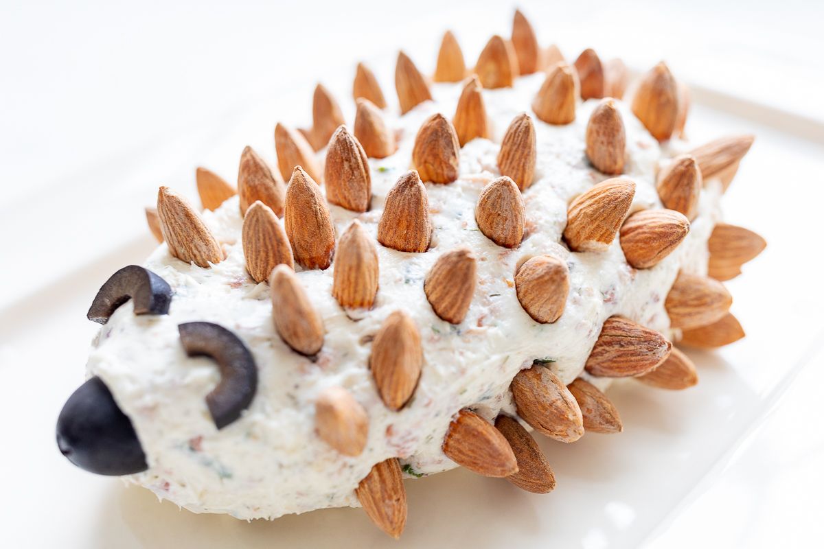 Hedgehog cheese ball on a white plate.