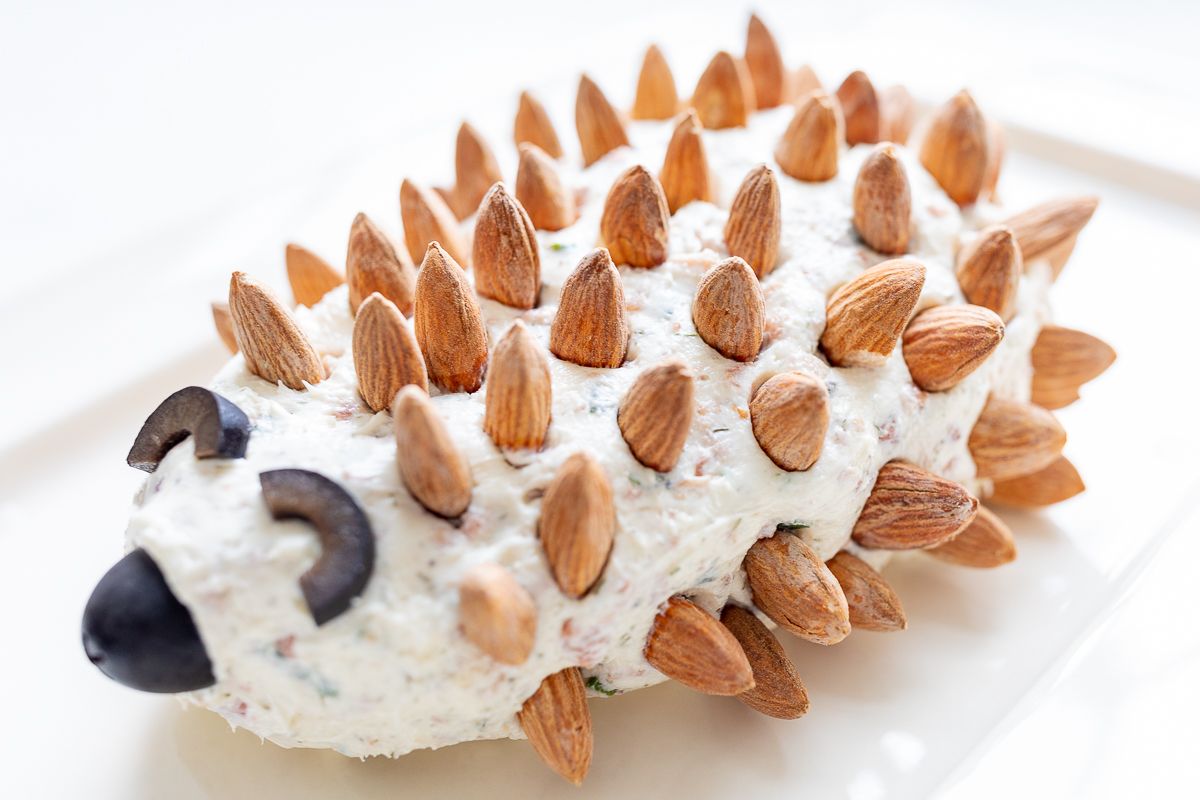 A hedgehog cheese ball on a white plate.