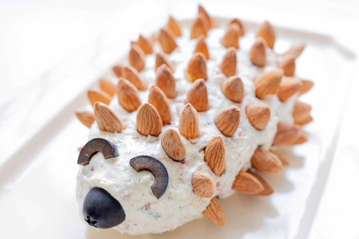 Hedgehog cheese ball on a white plate.
