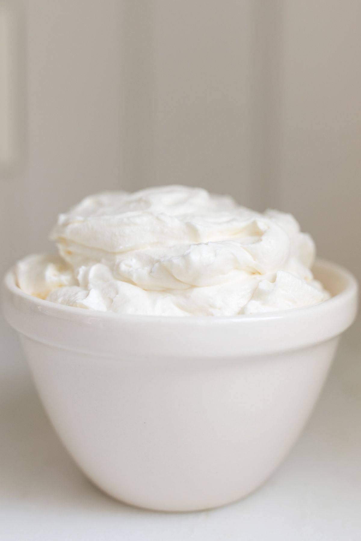 A white bowl full of homemade whipped cream.