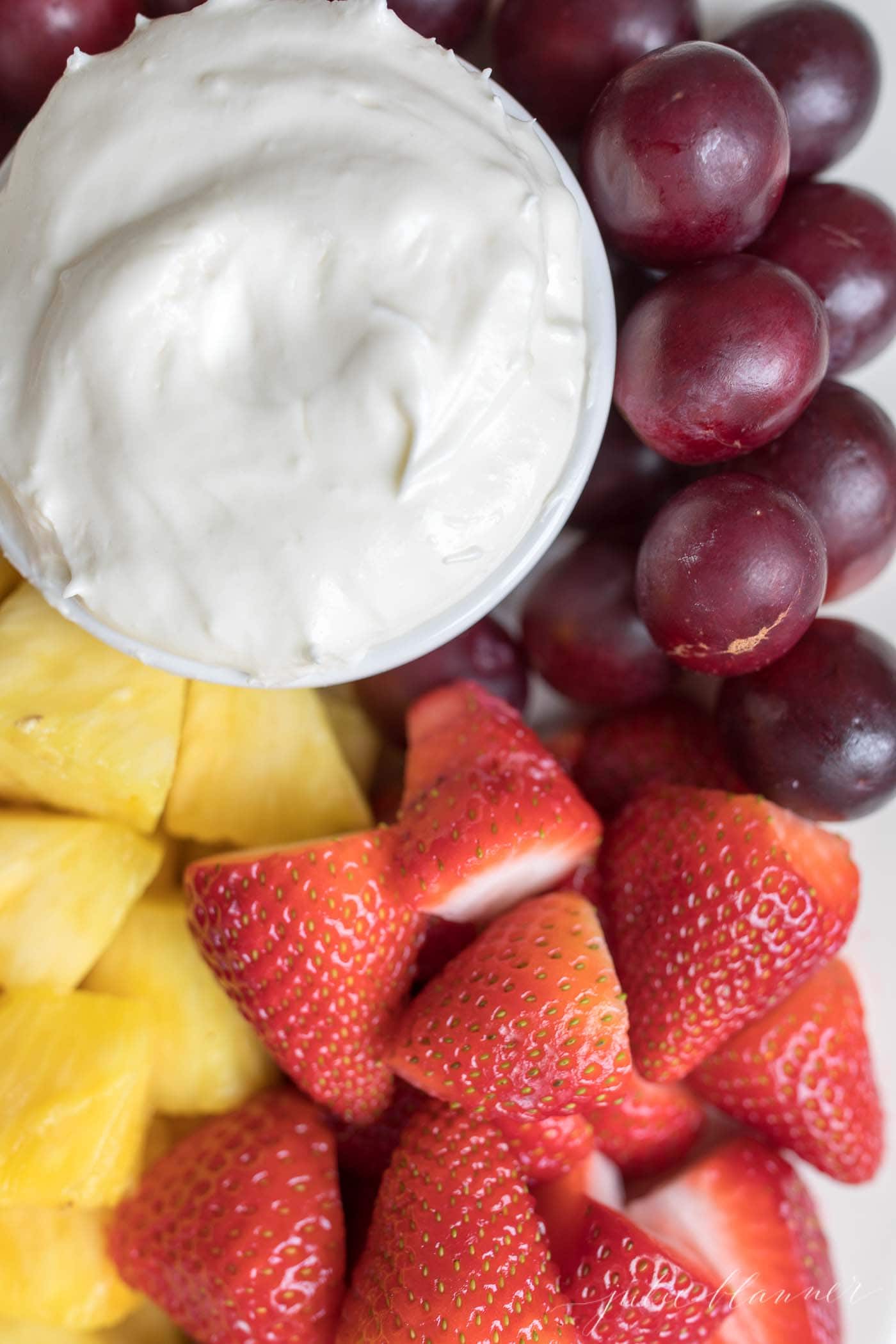 marshmallow fruit dip in a bowl with a platter of fruit