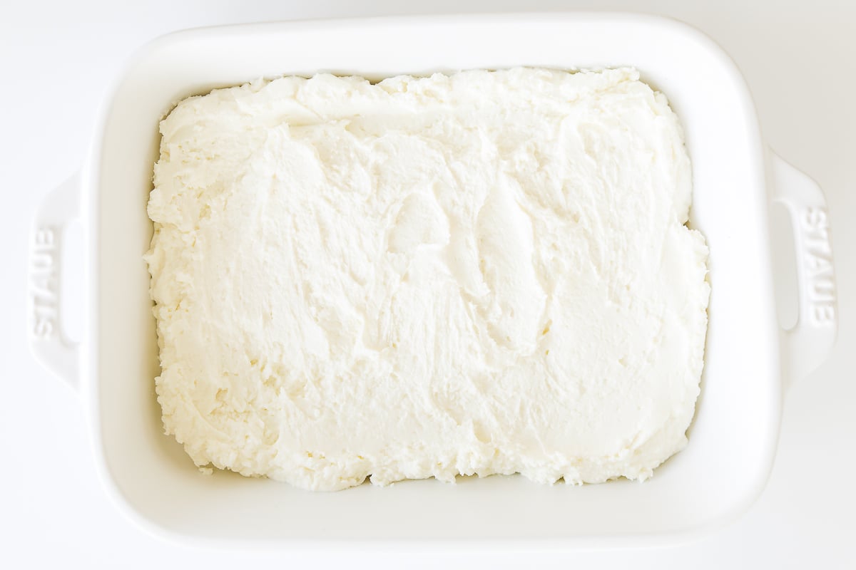 A white baking dish filled with whipped cream.