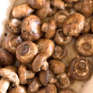 Oven Roasted Mushrooms in a white dish on a table.