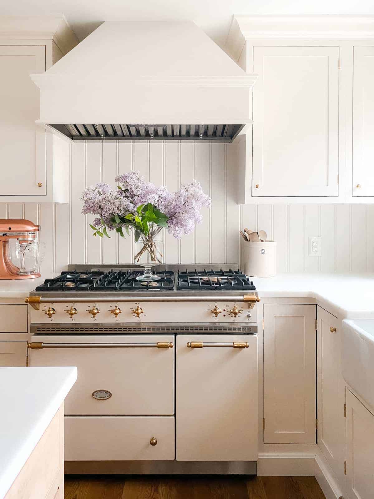 cream kitchen with lacanche range and lilacs