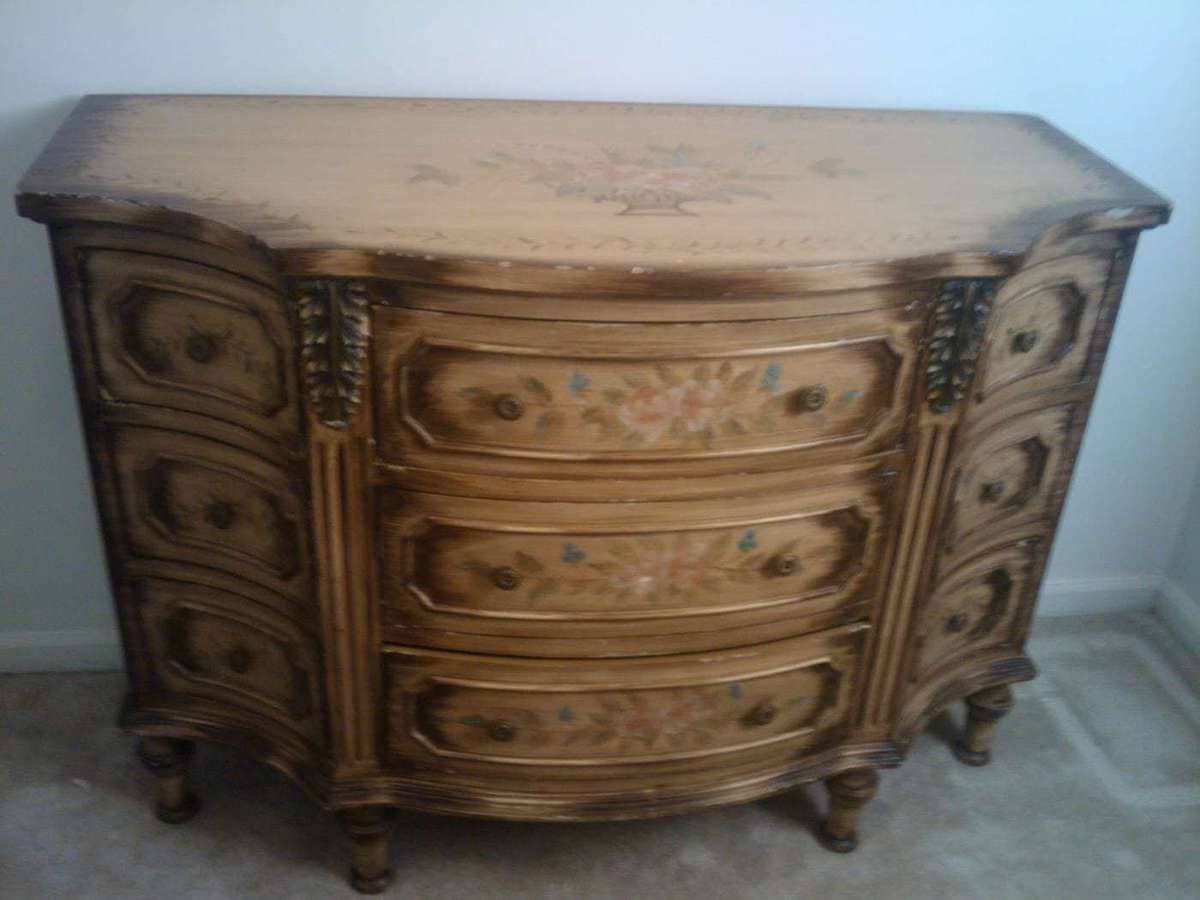 An old dresser with vintage inspired floral elements painted on.