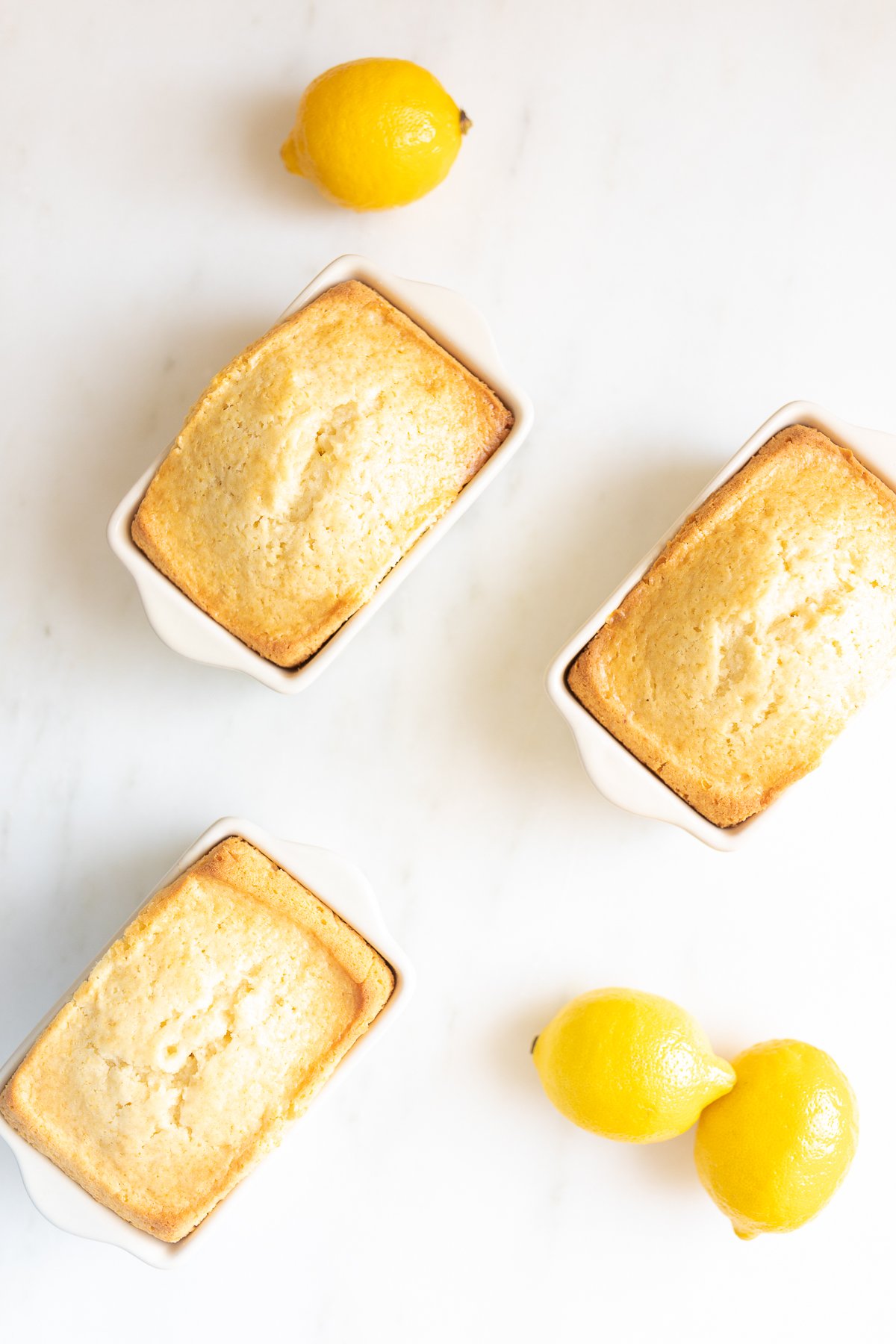 Mini lemon loaves on a white countertop.