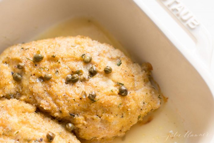 piccata milanese in baking dish with capers on top