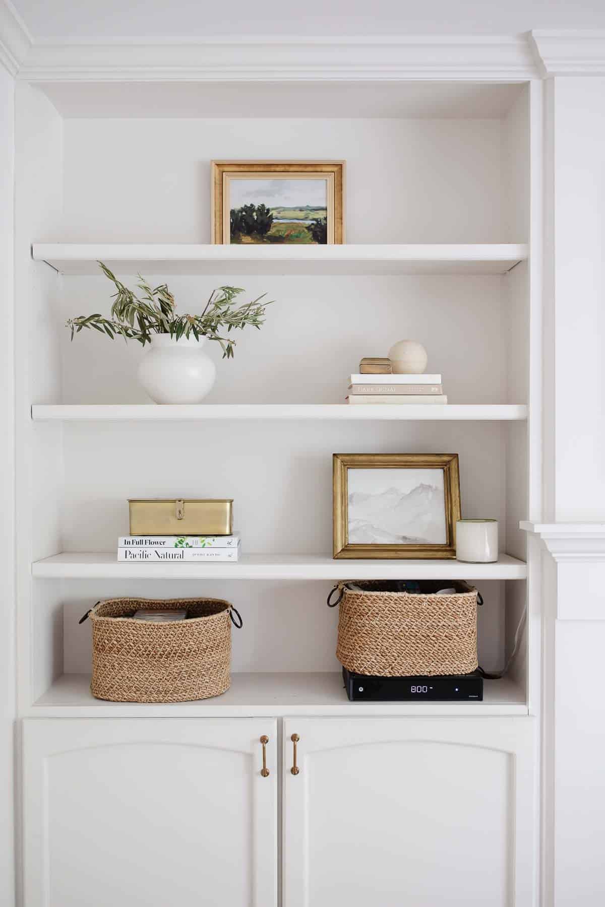 Built in bookcases with minimal baskets paintings and accessories