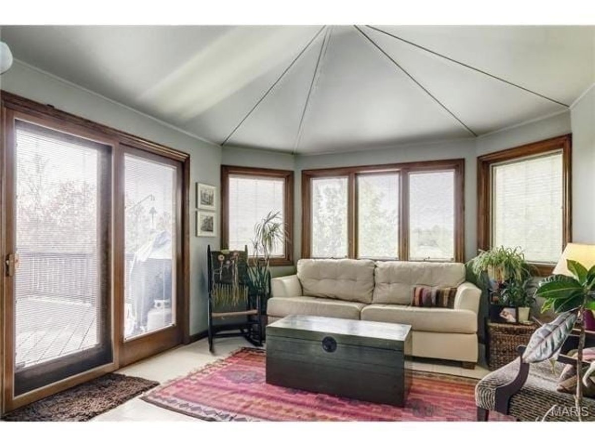 A dated room with wood windows and a peaked ceiling.