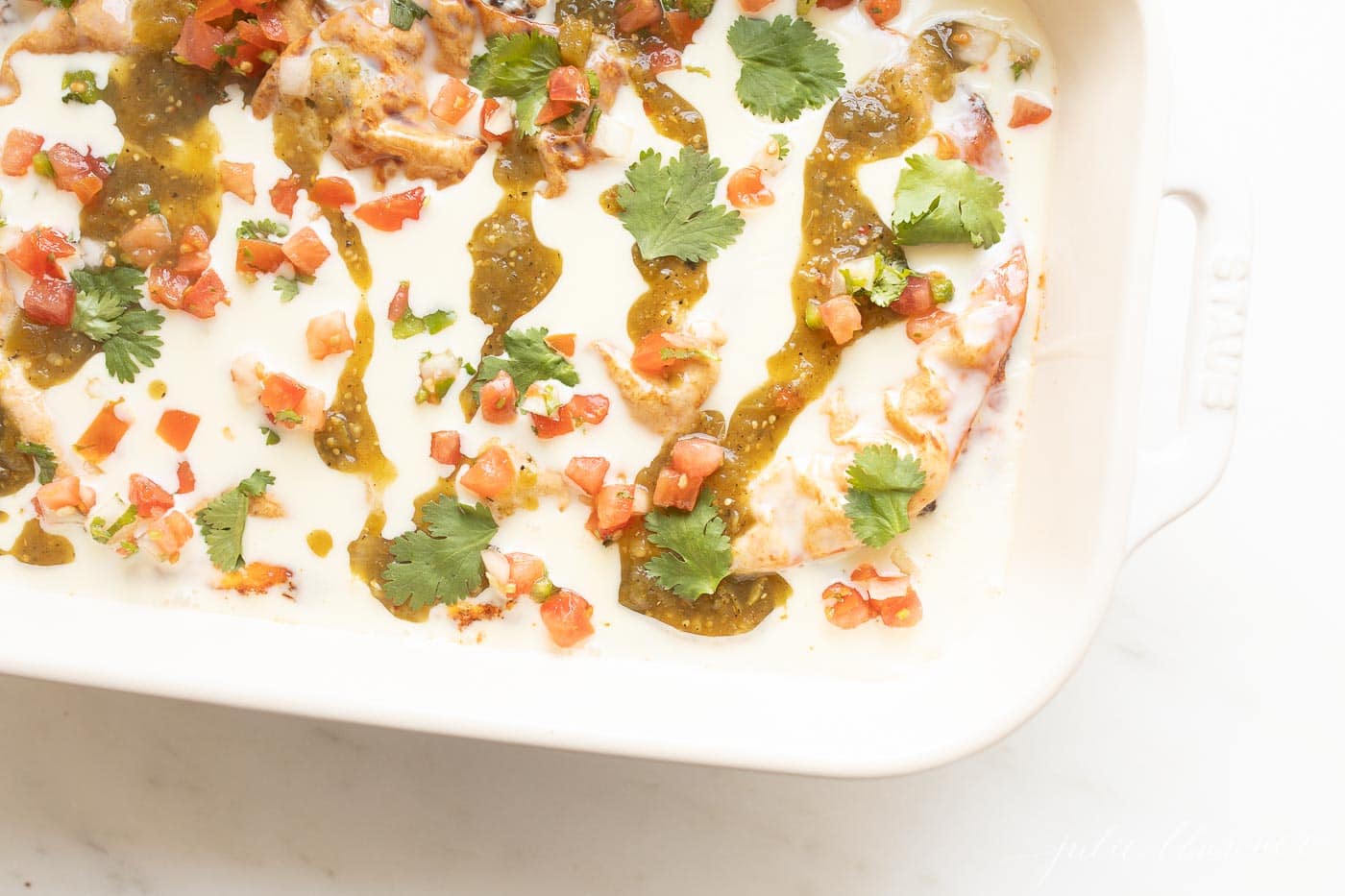 A breakfast burrito casserole topped with queso and salsa