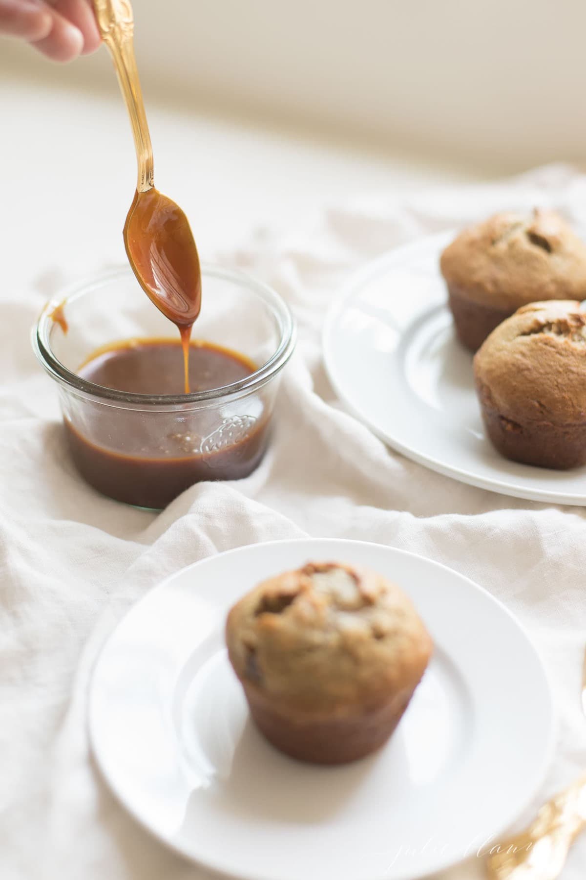 Caramel and Banana muffins being topped wit caramel.