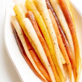 Candied carrots in a white dish.