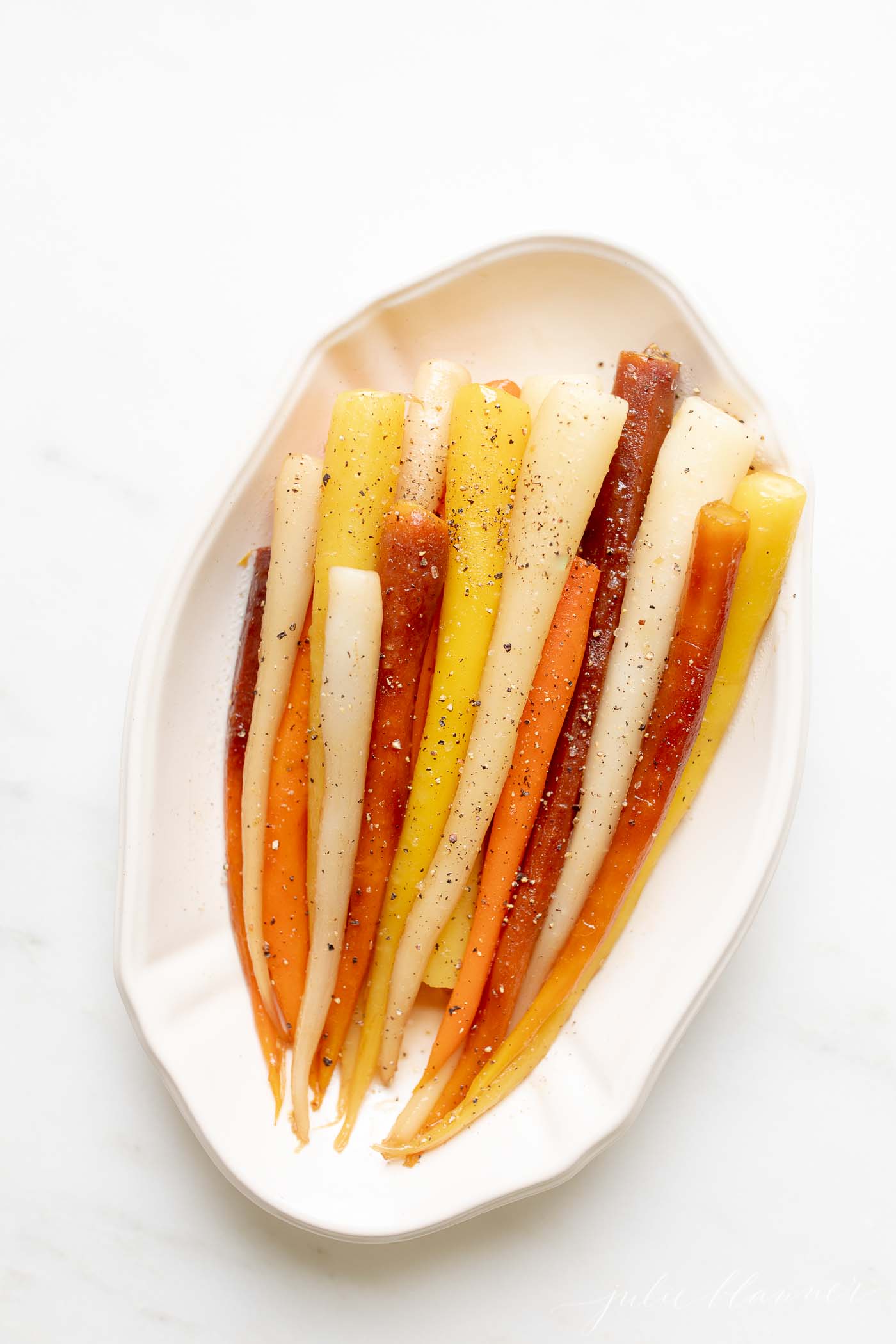 Colorful Candied carrots in a white serving dish