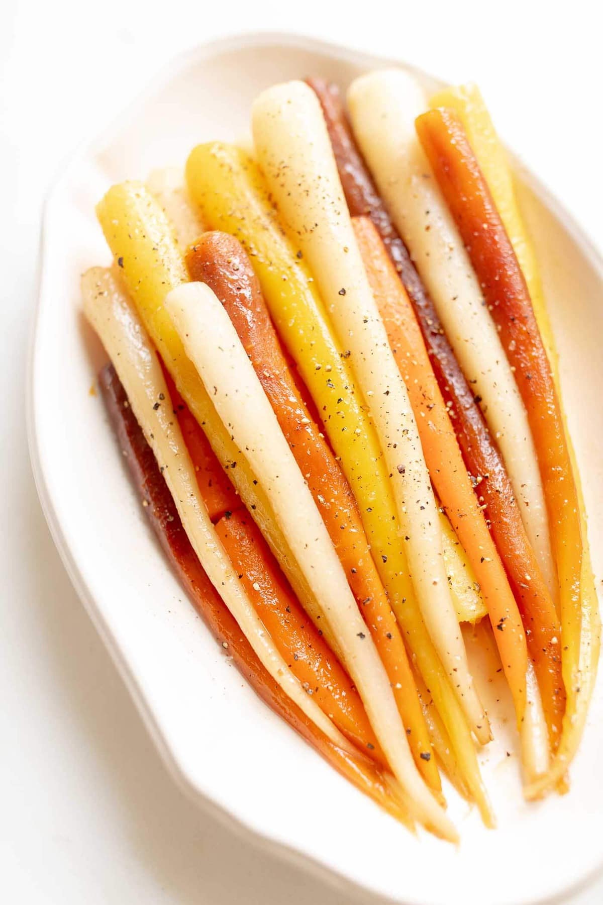 Candied carrots in a white dish.