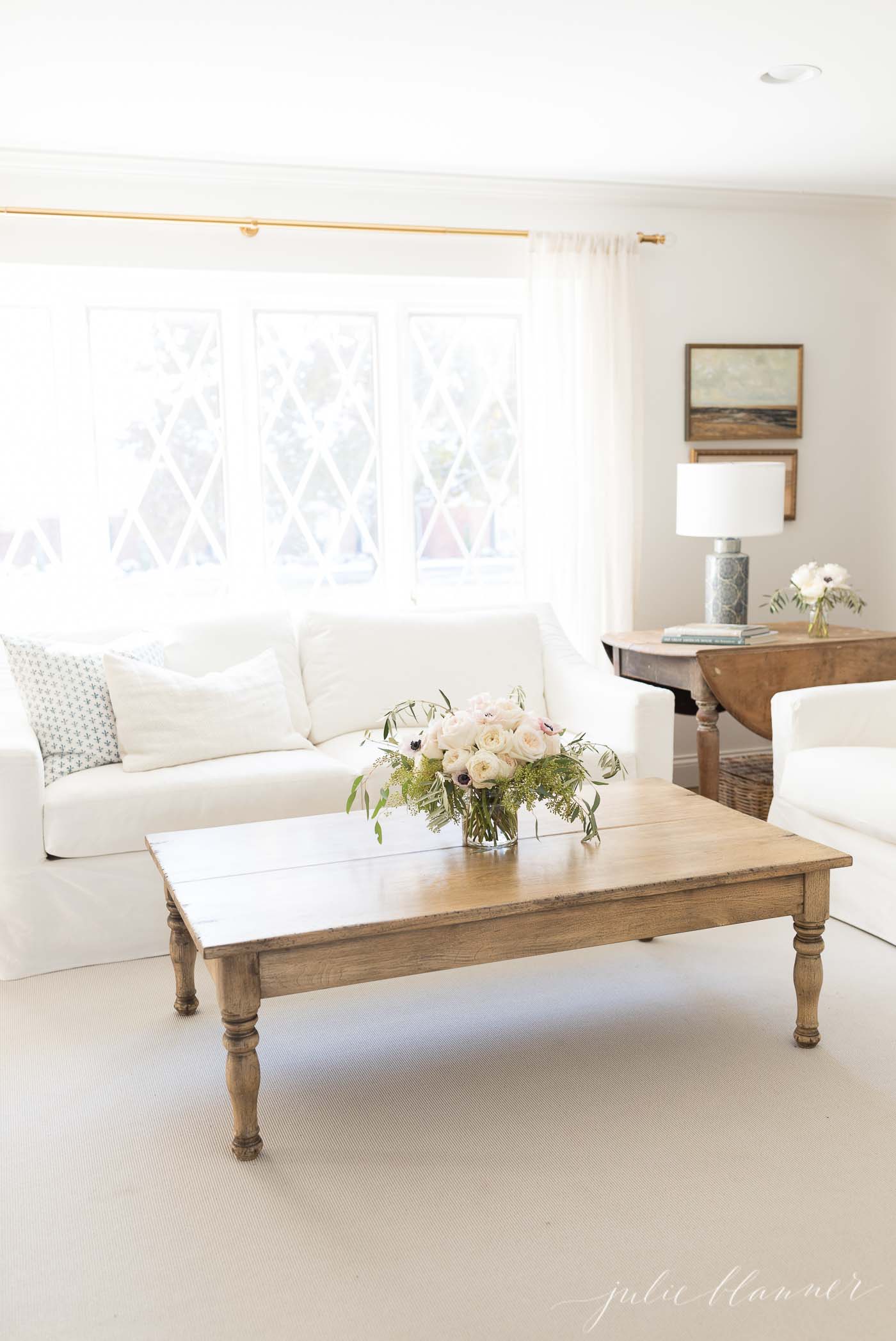 neutral living room with wood coffee table, white sofas