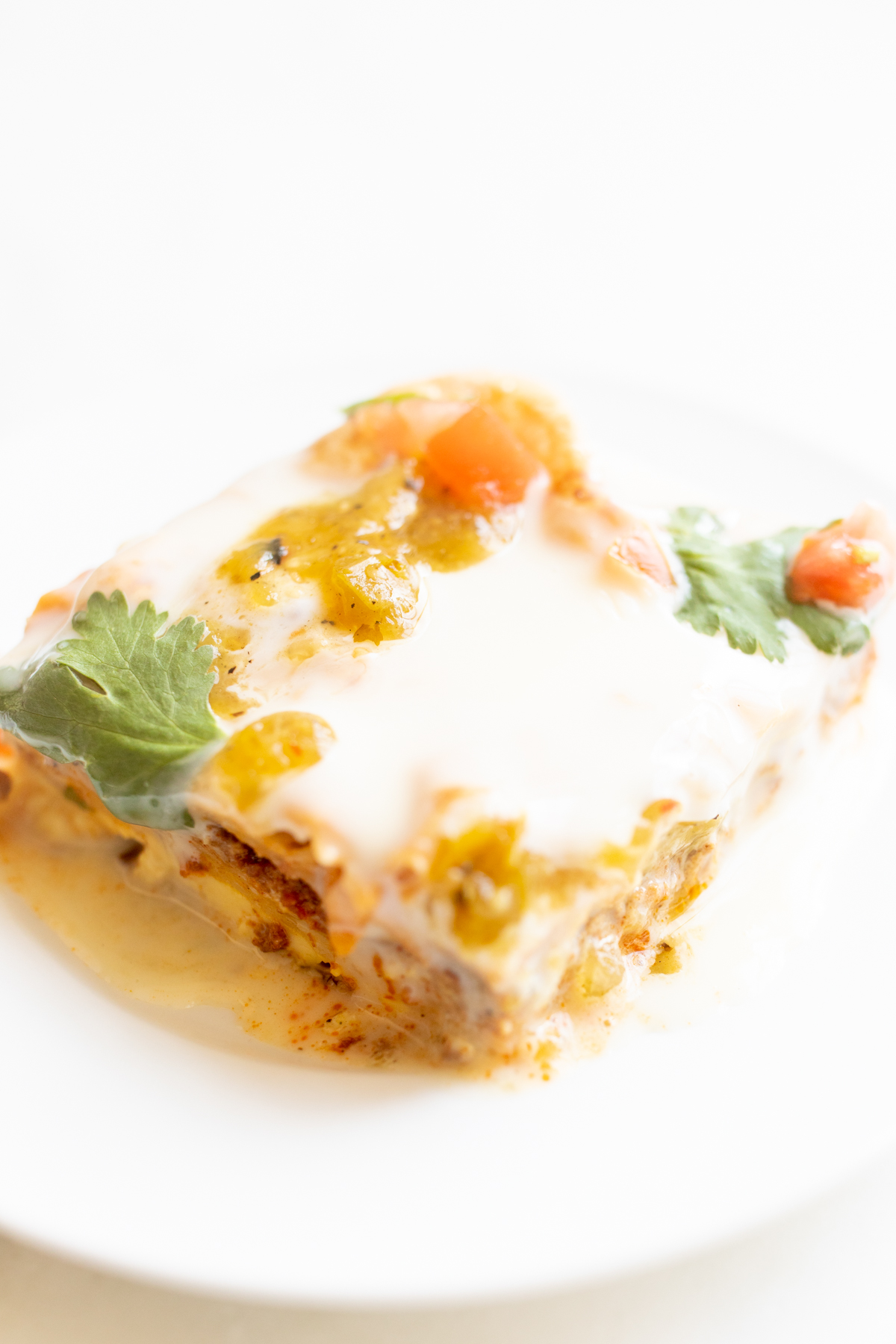 A slice of Mexican breakfast casserole on a white plate.