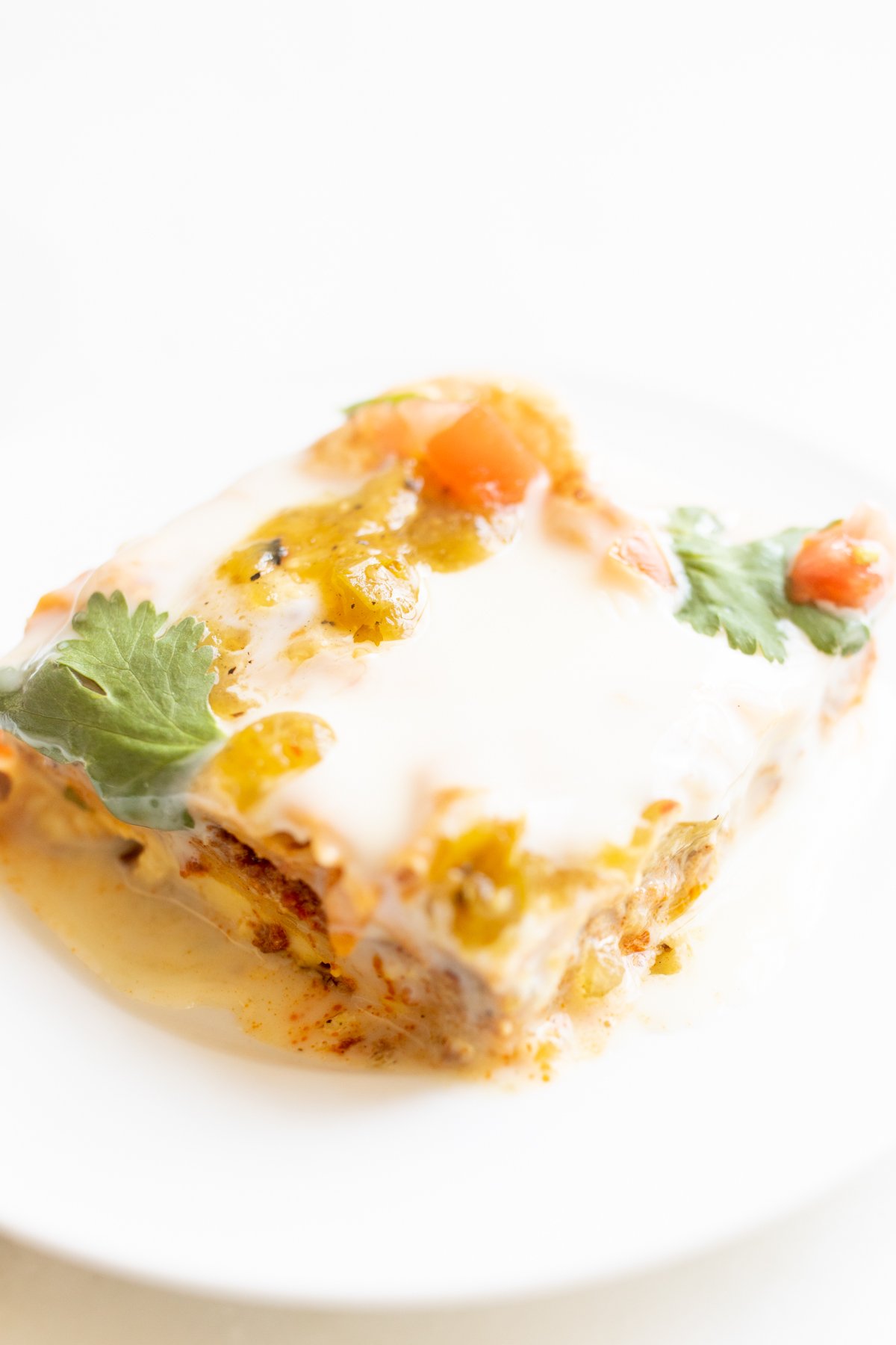 A slice of Mexican breakfast casserole on a white plate.