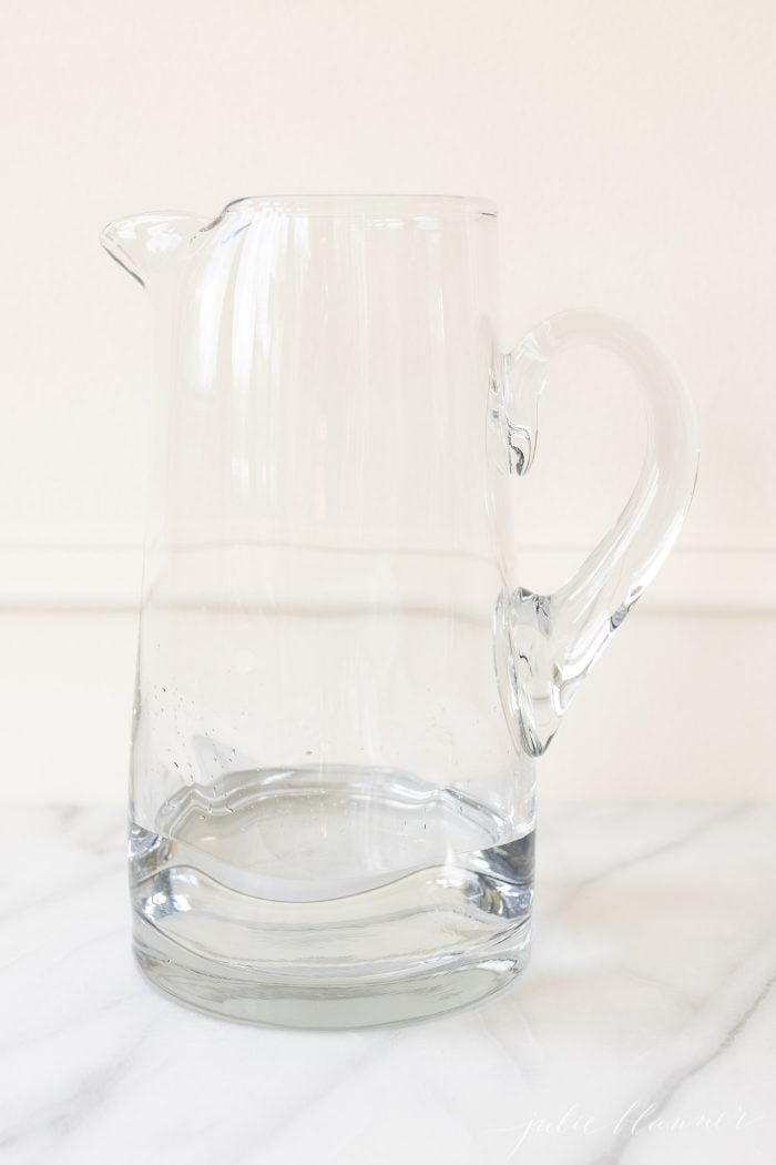 A glass pitcher on a marble surface
