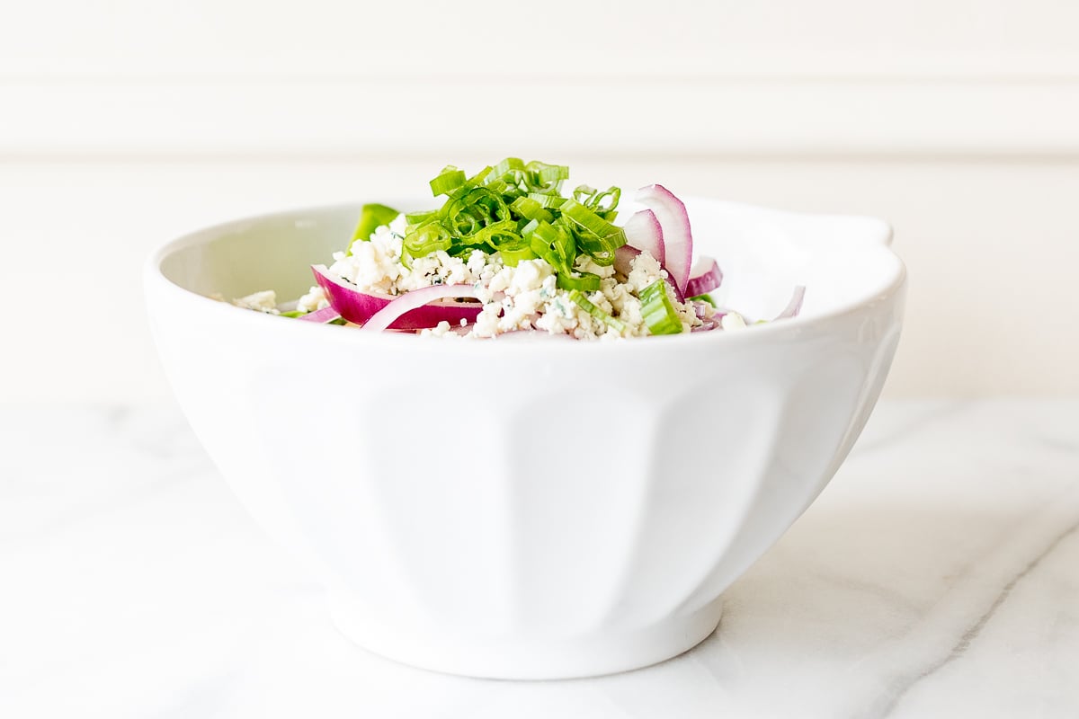 A white bowl full of homemade apple salad.