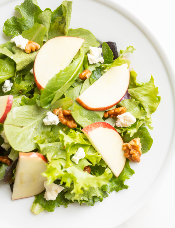 A white plate filled with an apple salad.