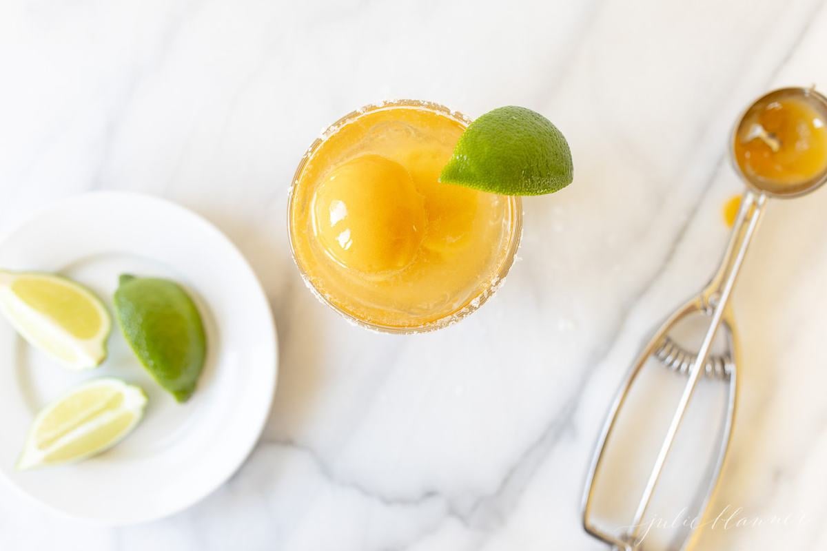 A margarita float made with mango sorbet, slice of lime on the glass