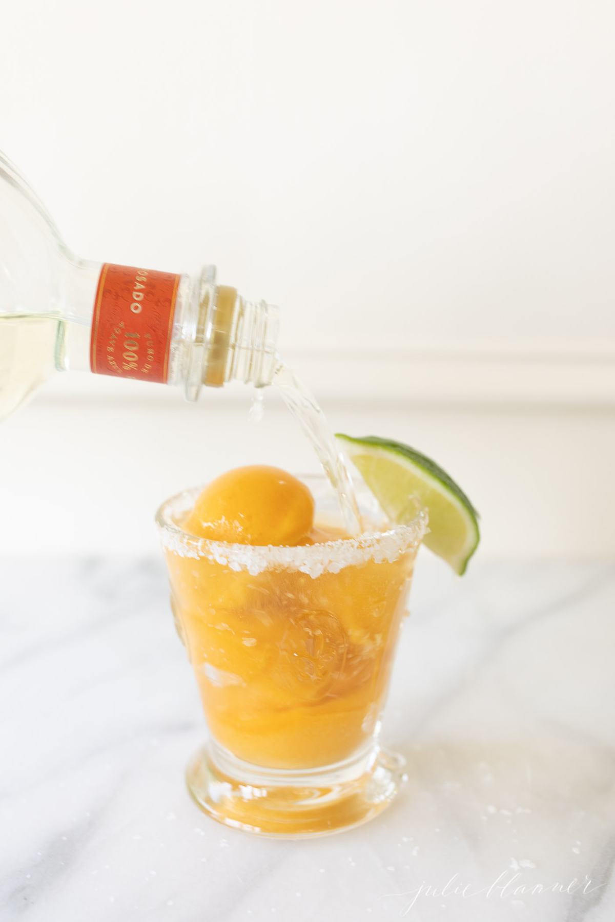 tequila pour into mango margarita