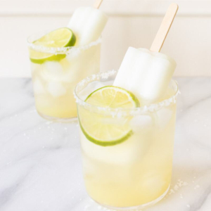 Two glasses of margaritas with lime popsicles.