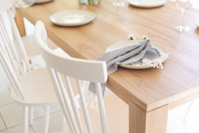 teak dining table with white chairs