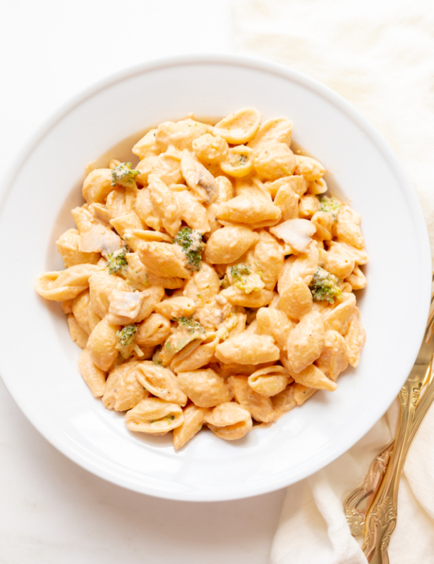 A white plate of pasta con broccoli.