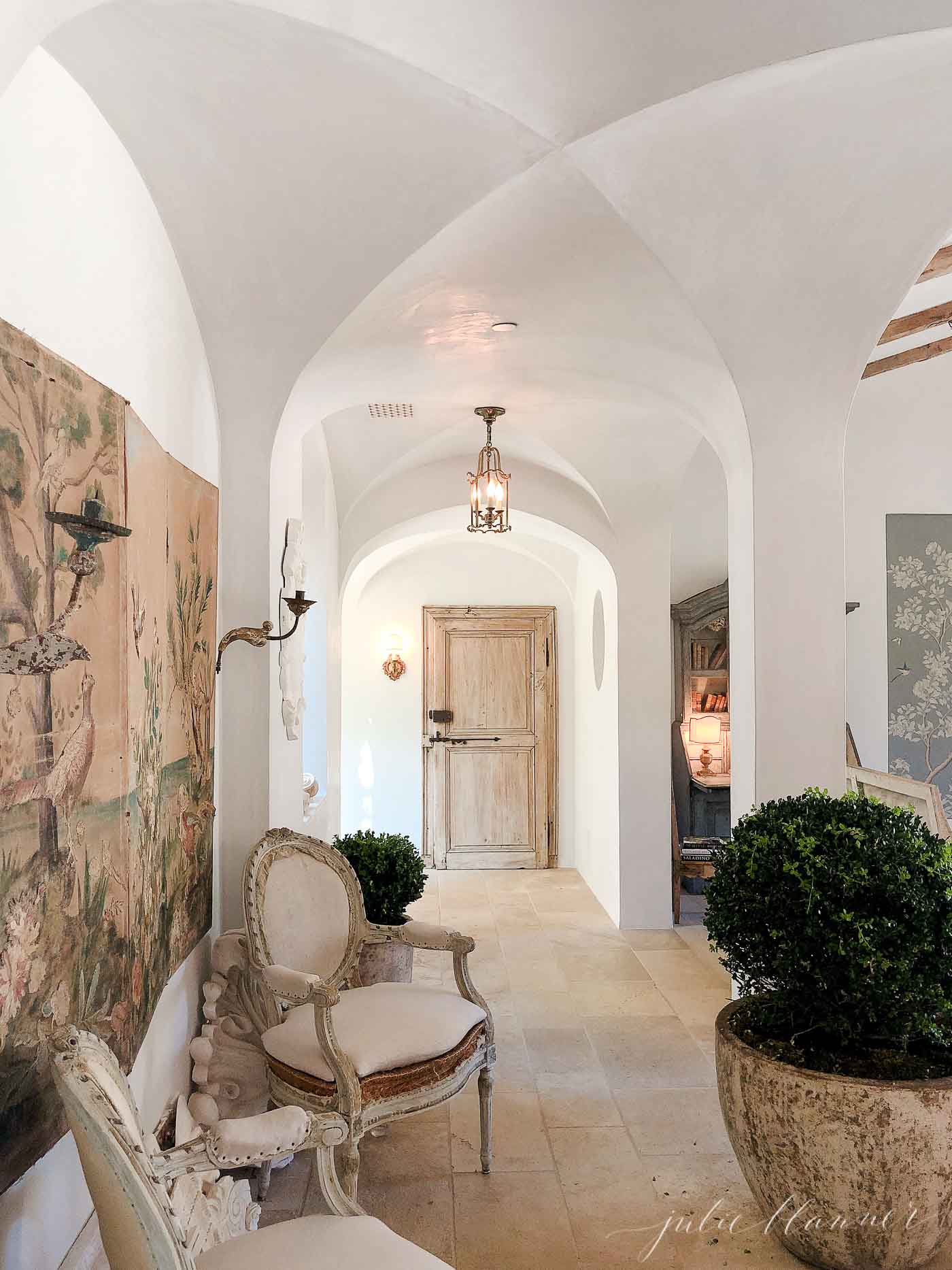 French farmhouse entryway with beautiful chair and tapestry