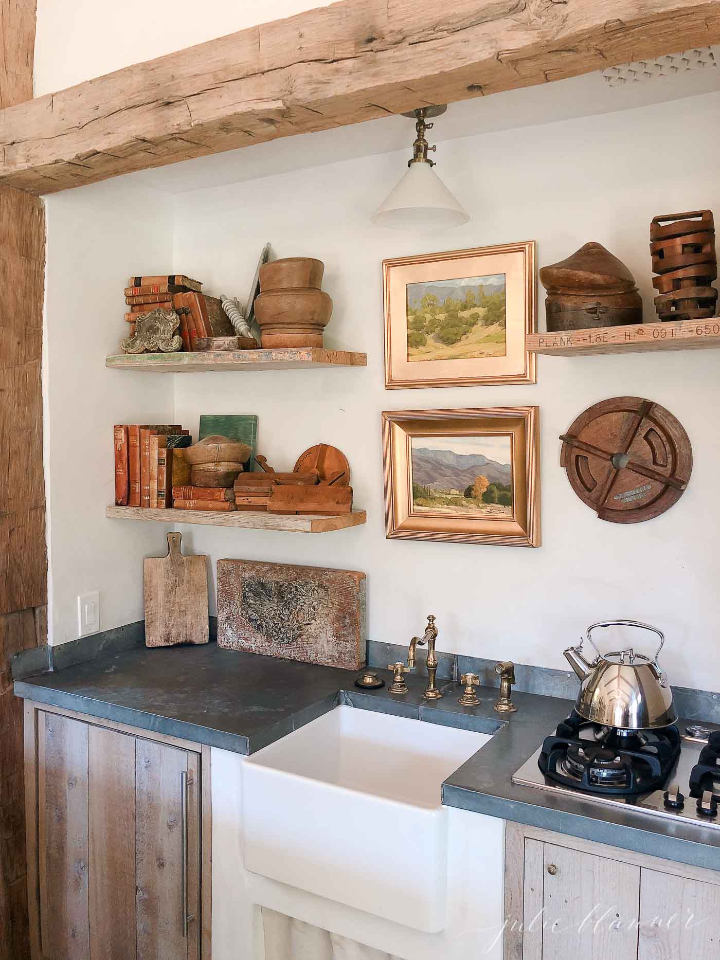 Country decor, with pottery on shelves with art wood beams soapstone counters and farmhouse sink