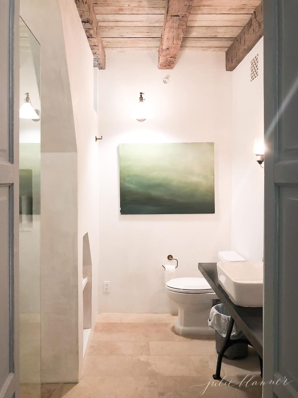 bathroom with wood beams and oversized art.