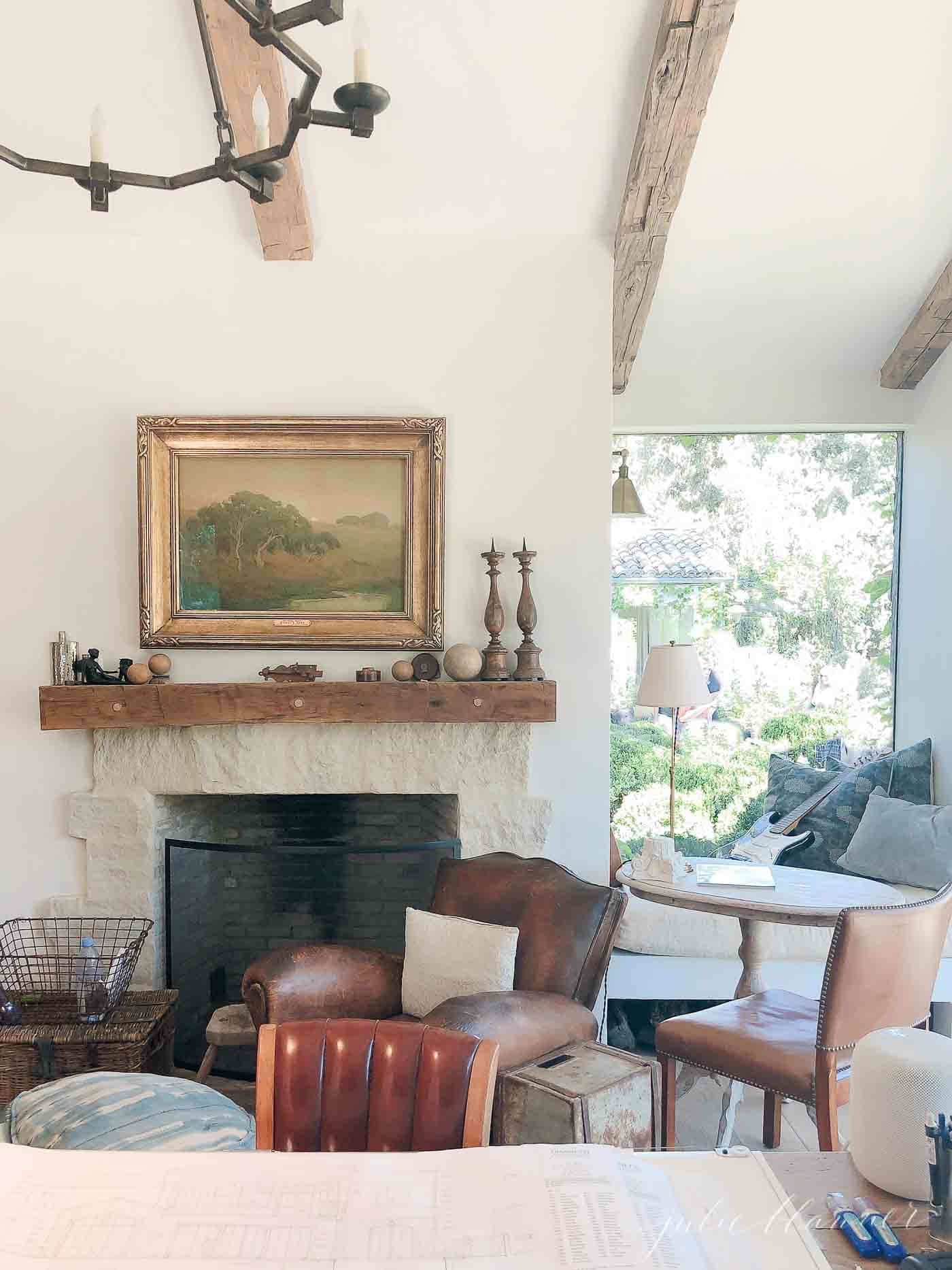 Living room with rustic mantel, chairs and painting.