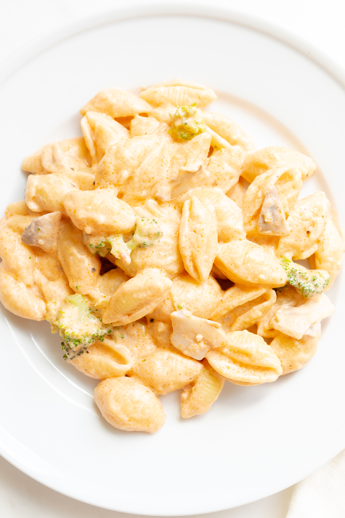 A white plate of pasta con broccoli.