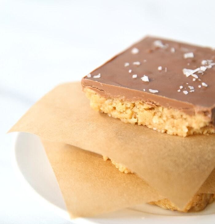 A stack of no-bake peanut butter bars topped with chocolate and sea salt flakes.