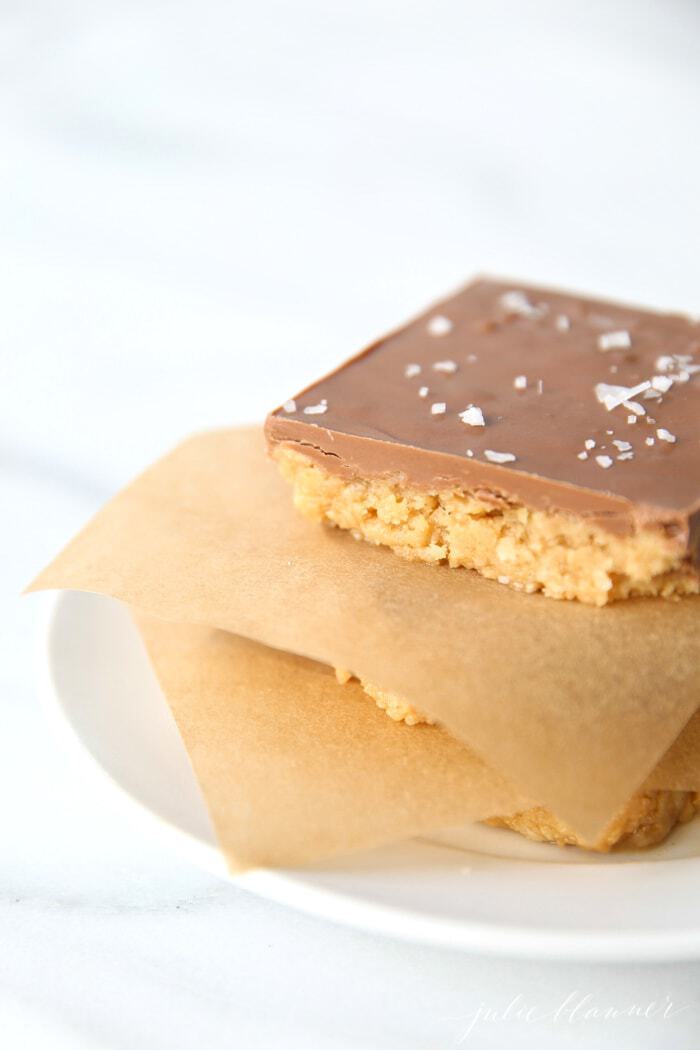 A stack of no-bake peanut butter bars topped with chocolate and sea salt flakes.