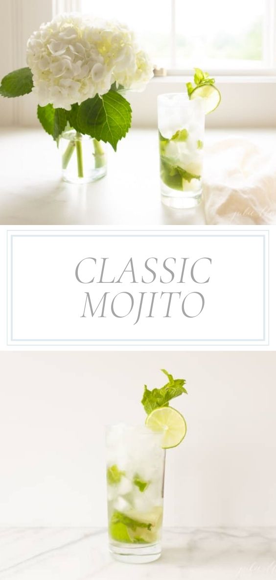 On a marble counter top, there is a vase of hydrangeas and a mojito in a tall glass with lime and mint.