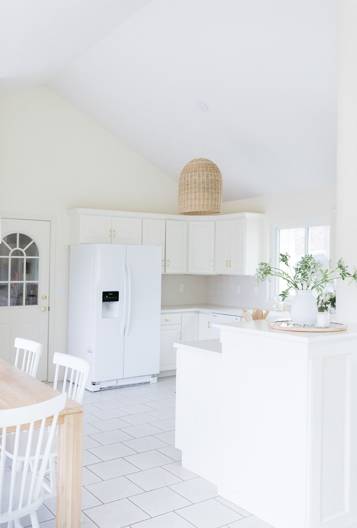 A white kitchen with white cabinets, white walls, and white ceiling paint. 