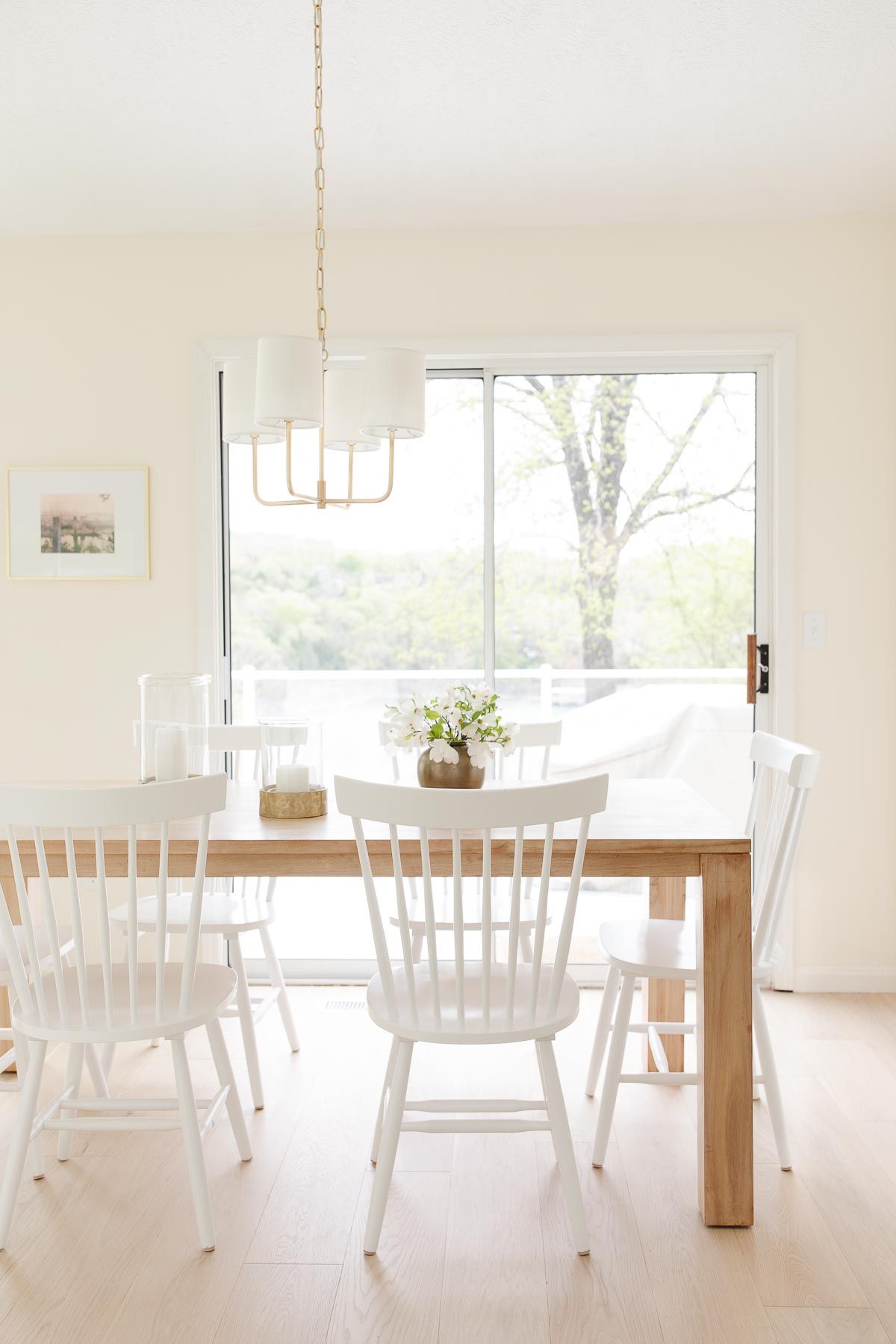 A kitchen table with a brass chandelier lighting design