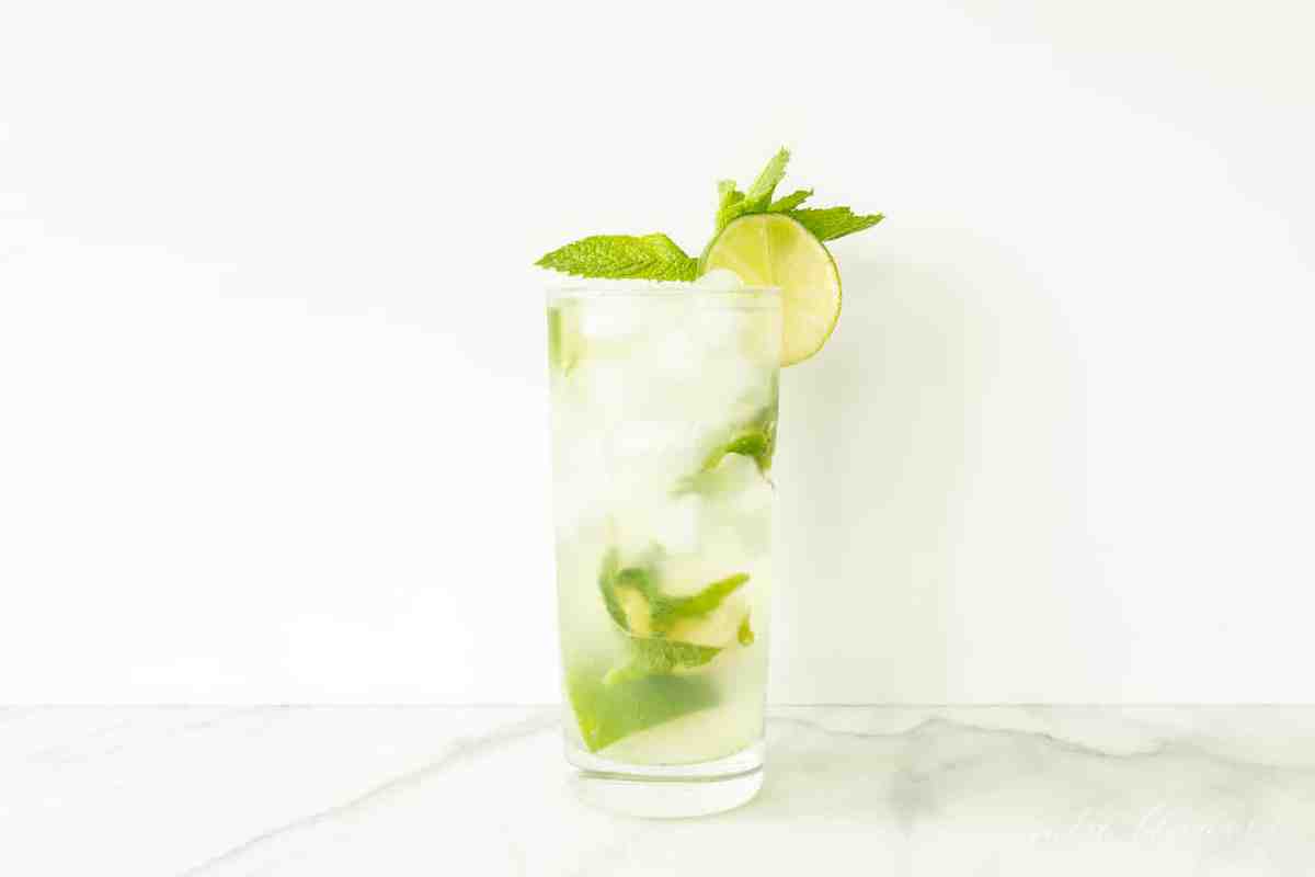 mojito recipe vodka in glass garnished with mint and lime slice on marble 