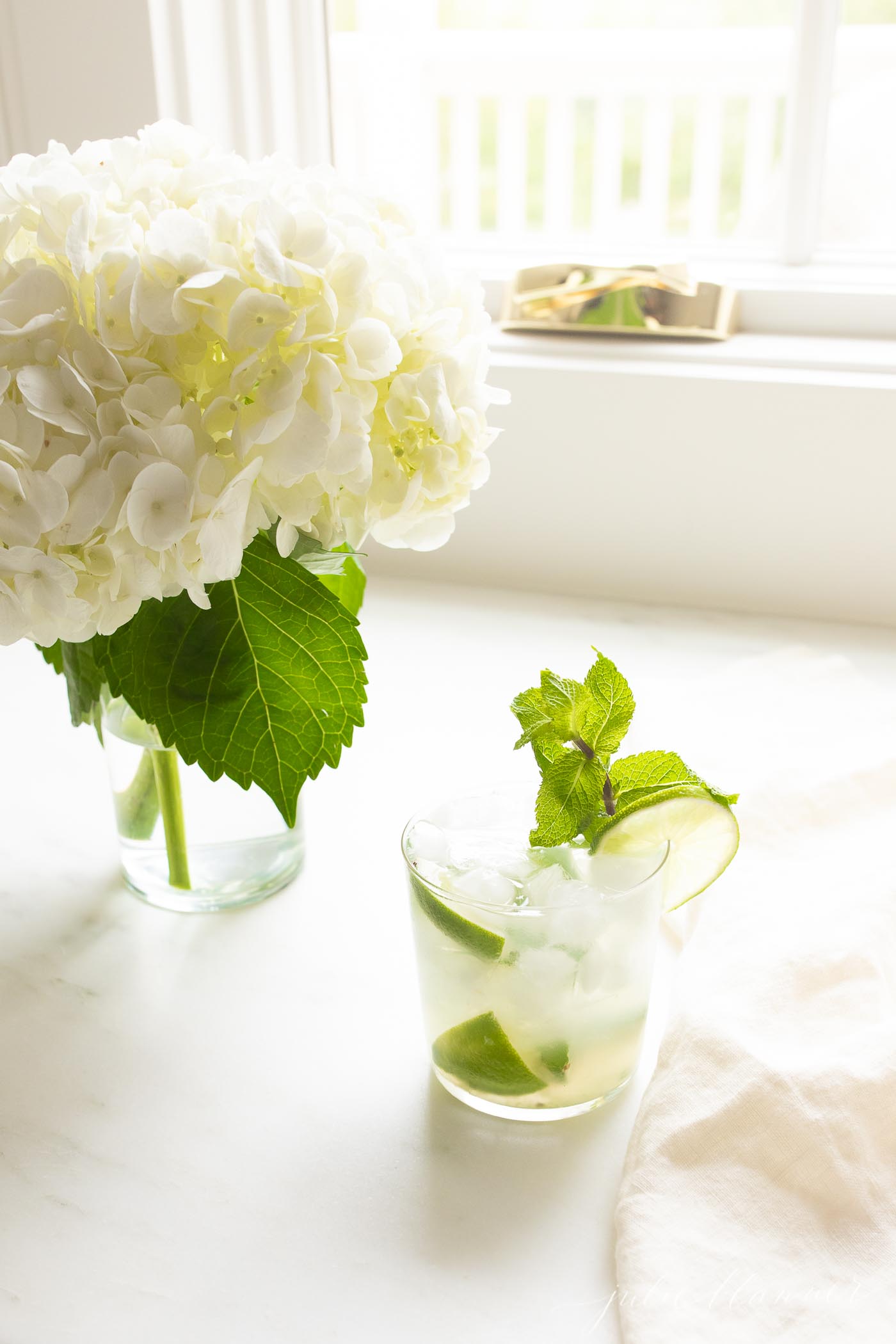 skinny mojito next to a vase of hydrangea