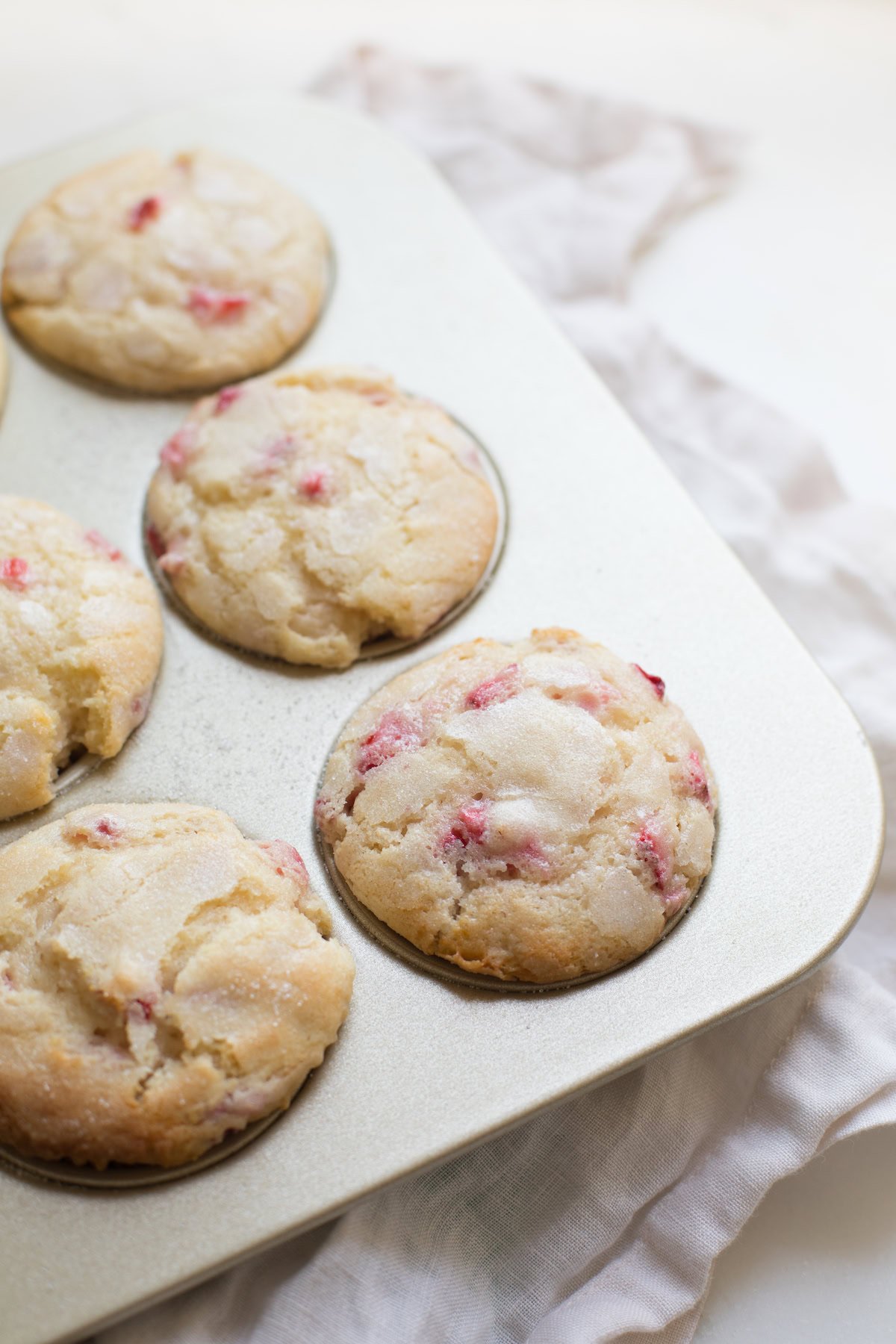 A muffin pan filled with fresh baked strawberry muffins.