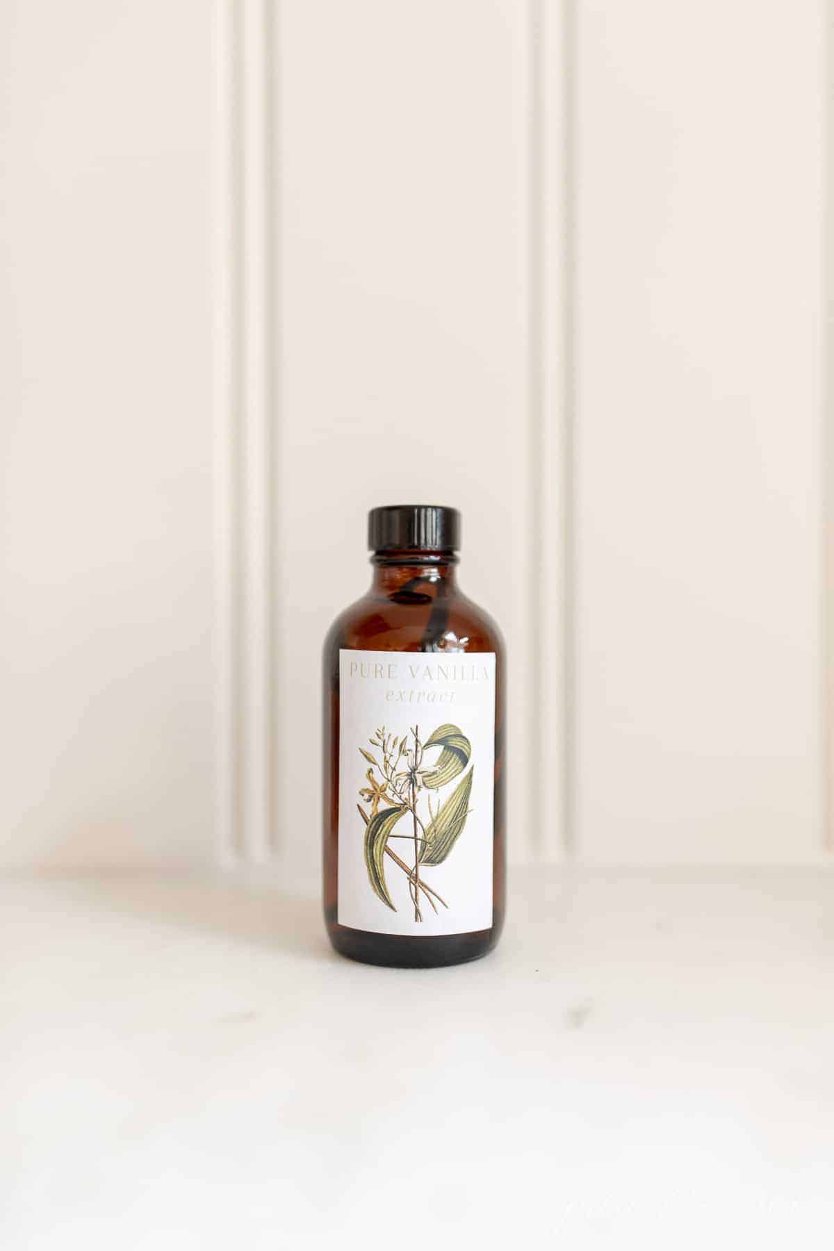 Homemade vanilla extract in an amber bottle on a white countertop. #homemadevanillaextract #vanilla #vanillabean