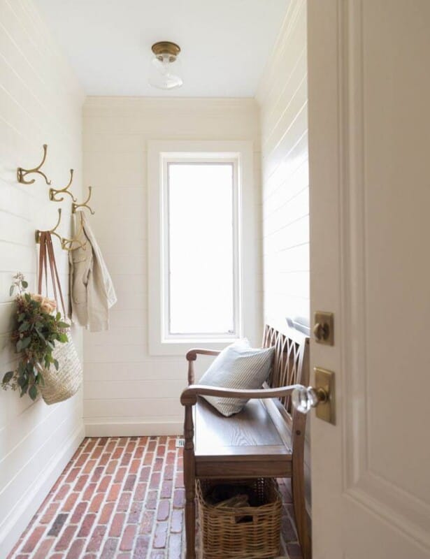 mudroom with brick floors, cream walls and white ceiling.