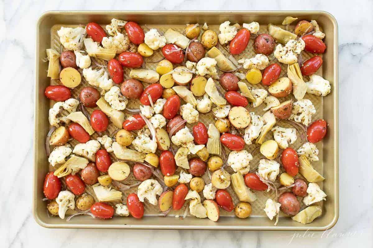 Gold sheet pan filled with seasoned roasted Italian vegetables. #italianvegetables