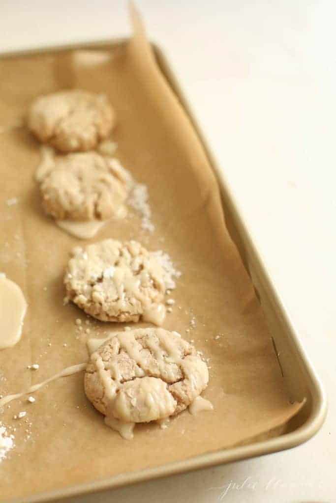 Apple glaze poured over cookies on a gold baking sheet. #appleglaze #appleciderglaze