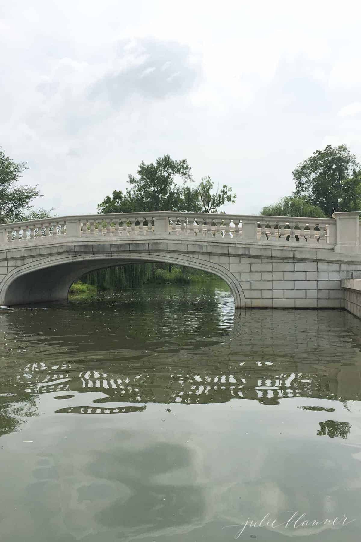 St. Louis boathouse bridge with water in the foreground.