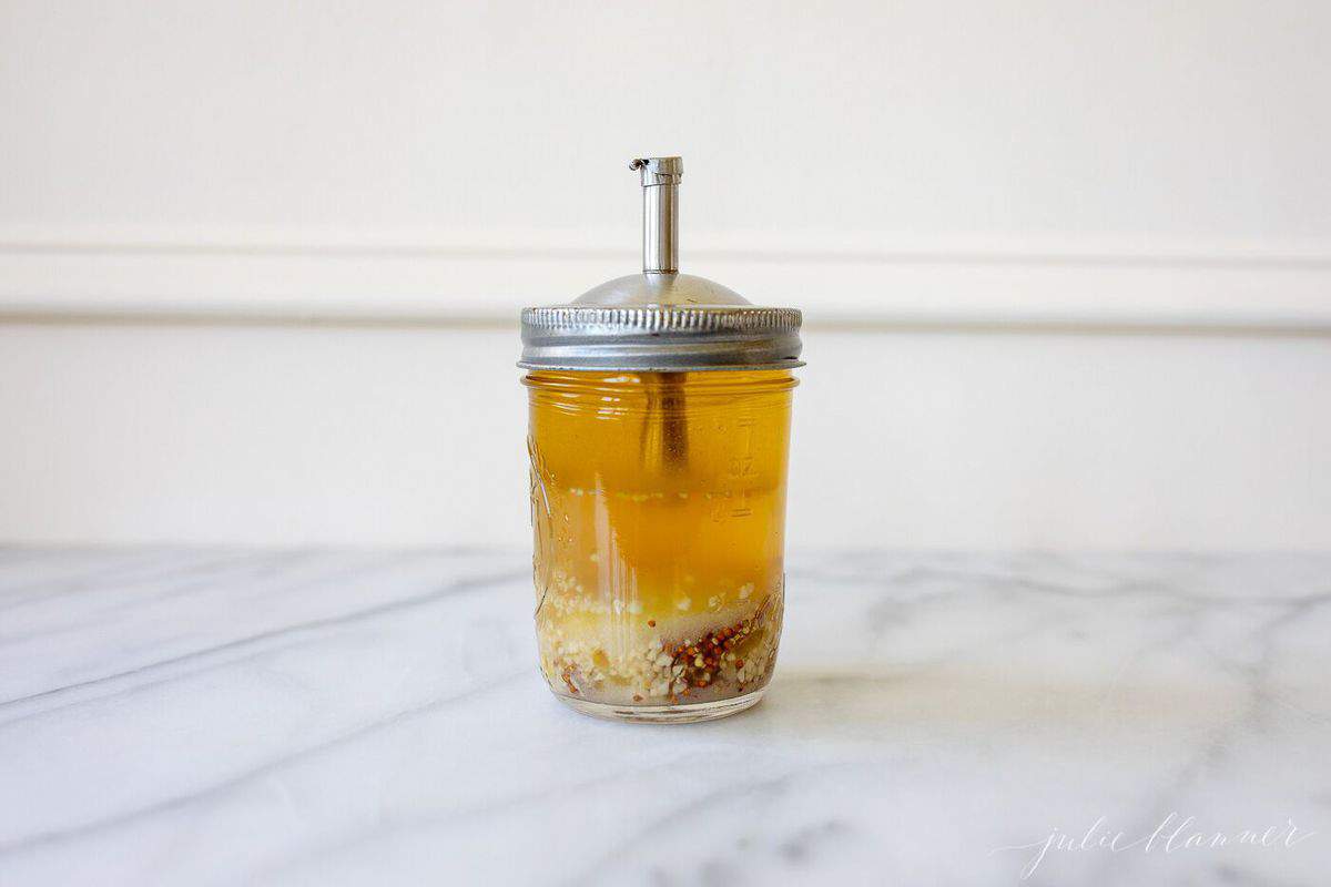 Salad dressing in a mason jar for serving, in a white kitchen. #cabbagesalad #cabbageslaw