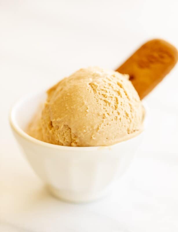 White bowl with two scoops of cookie butter ice cream, on a white surface. #cookiebuttericecream #speculoosicecream